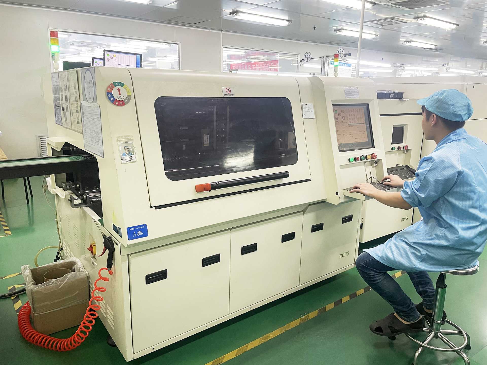 operator manning a wave soldering machine